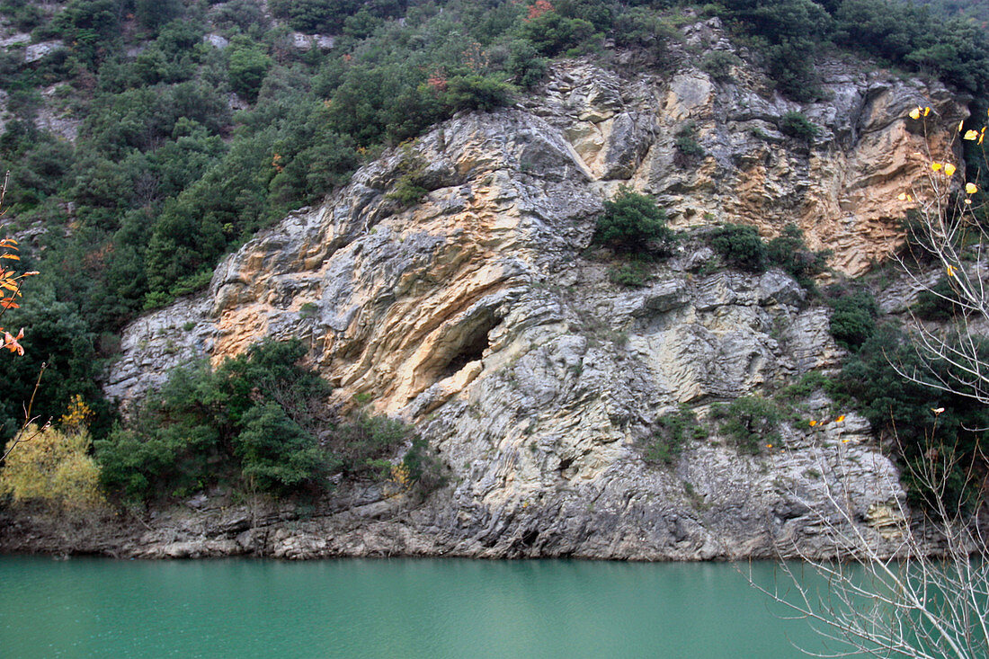 Folded rock strata by a lake
