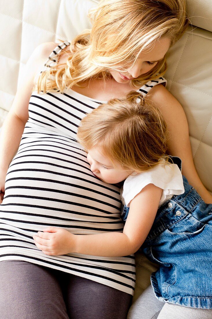 Pregnant mother and daughter resting