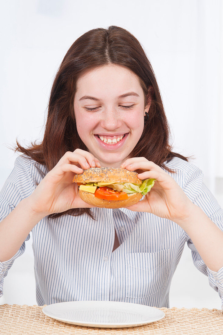 Young woman eating healthy sandwich