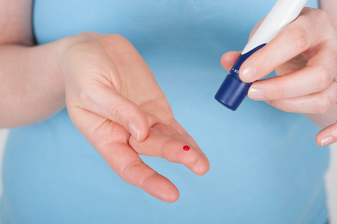 Young woman doing a finger prick test