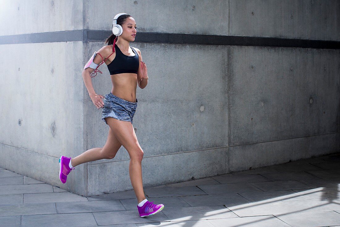 Woman wearing headphones running