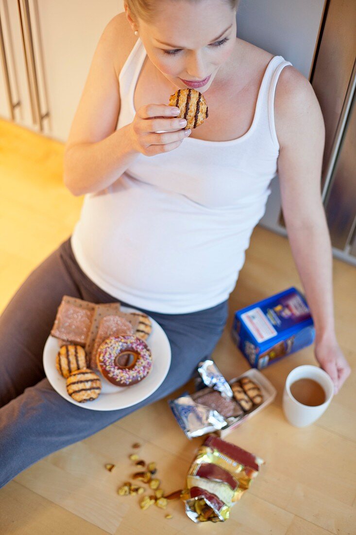 Pregnant woman eating biscuit