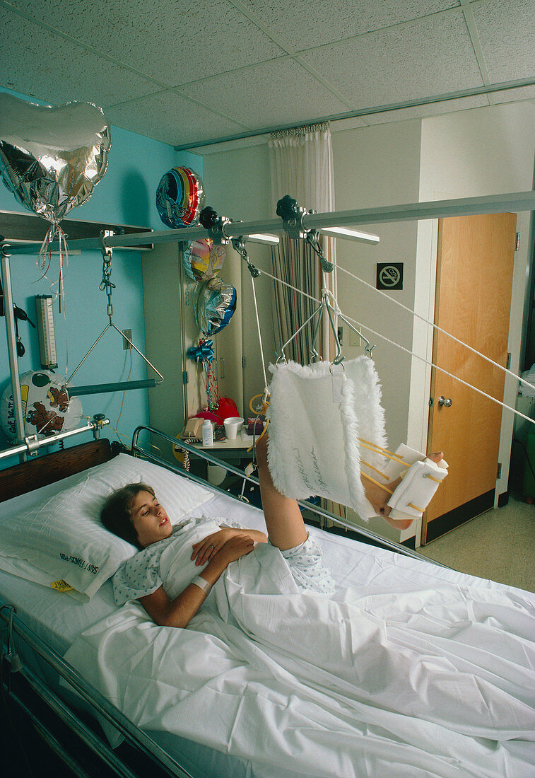Young woman in hospital bed undergoing traction__