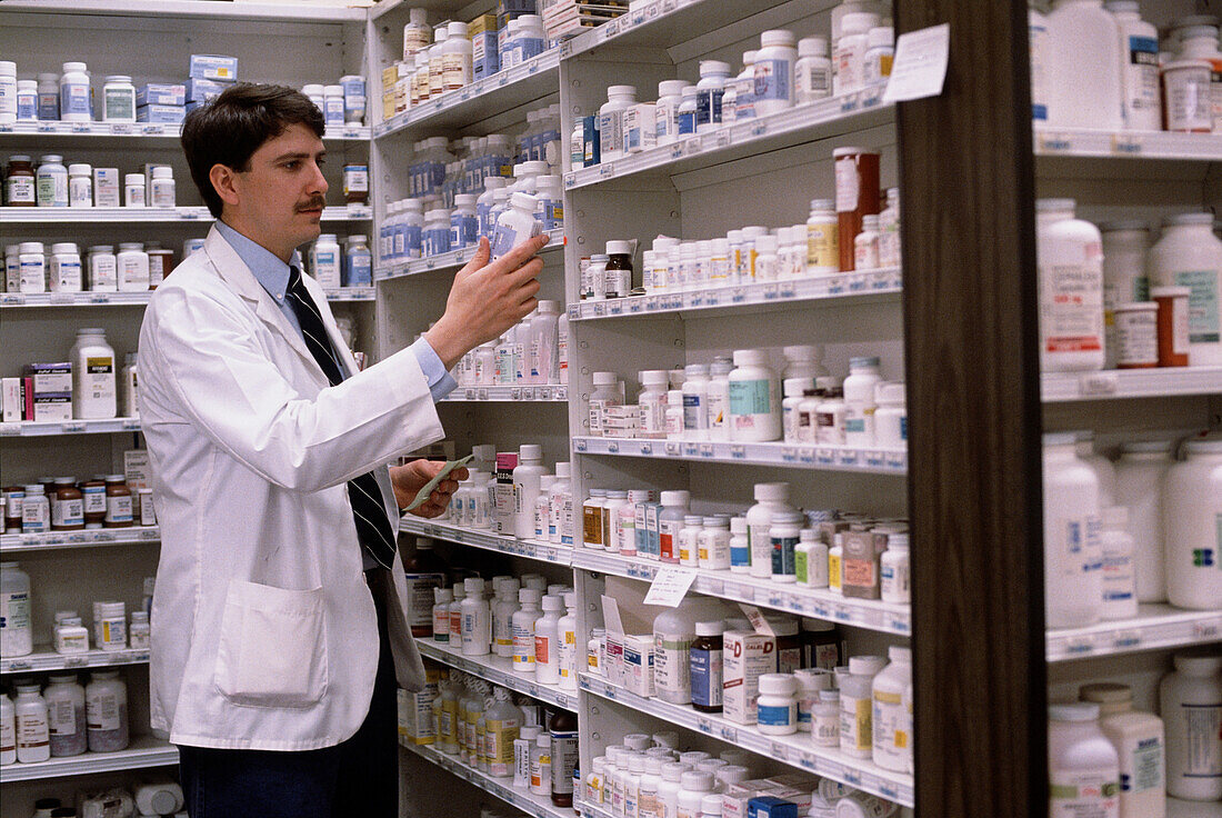 View of pharmacist with bottles of drugs