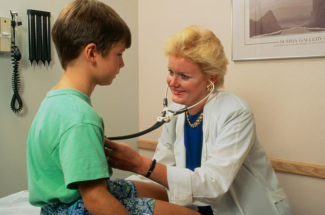 Doctor listening to a young boy's heart and lungs