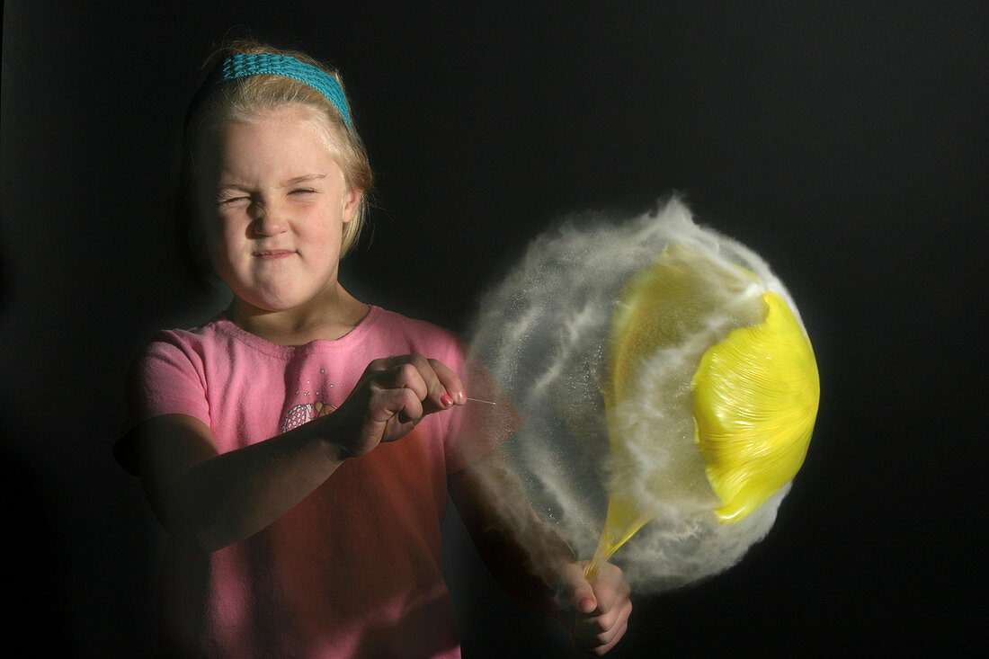 A girl pops a Balloon