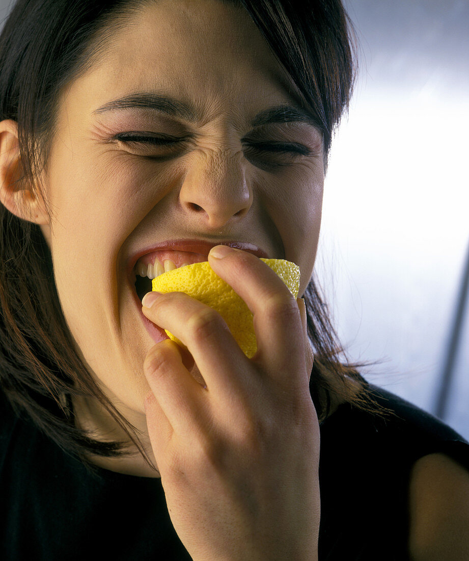 Woman biting a lemon