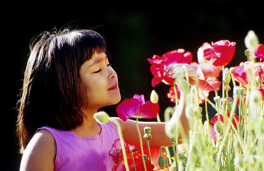 Asian girl admiring her flower garden