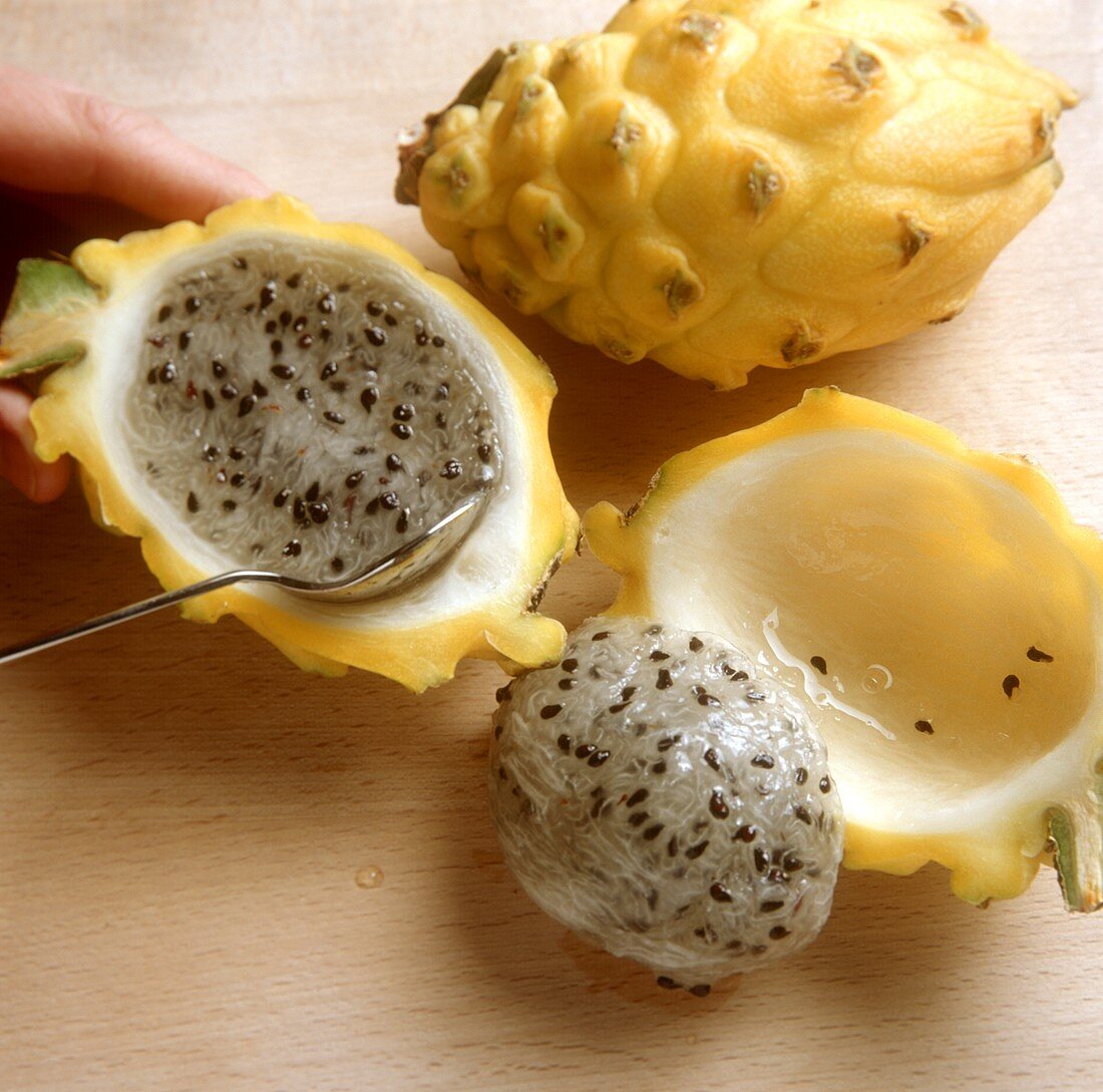 Peeling a pitahaya (loosening the flesh with a spoon)