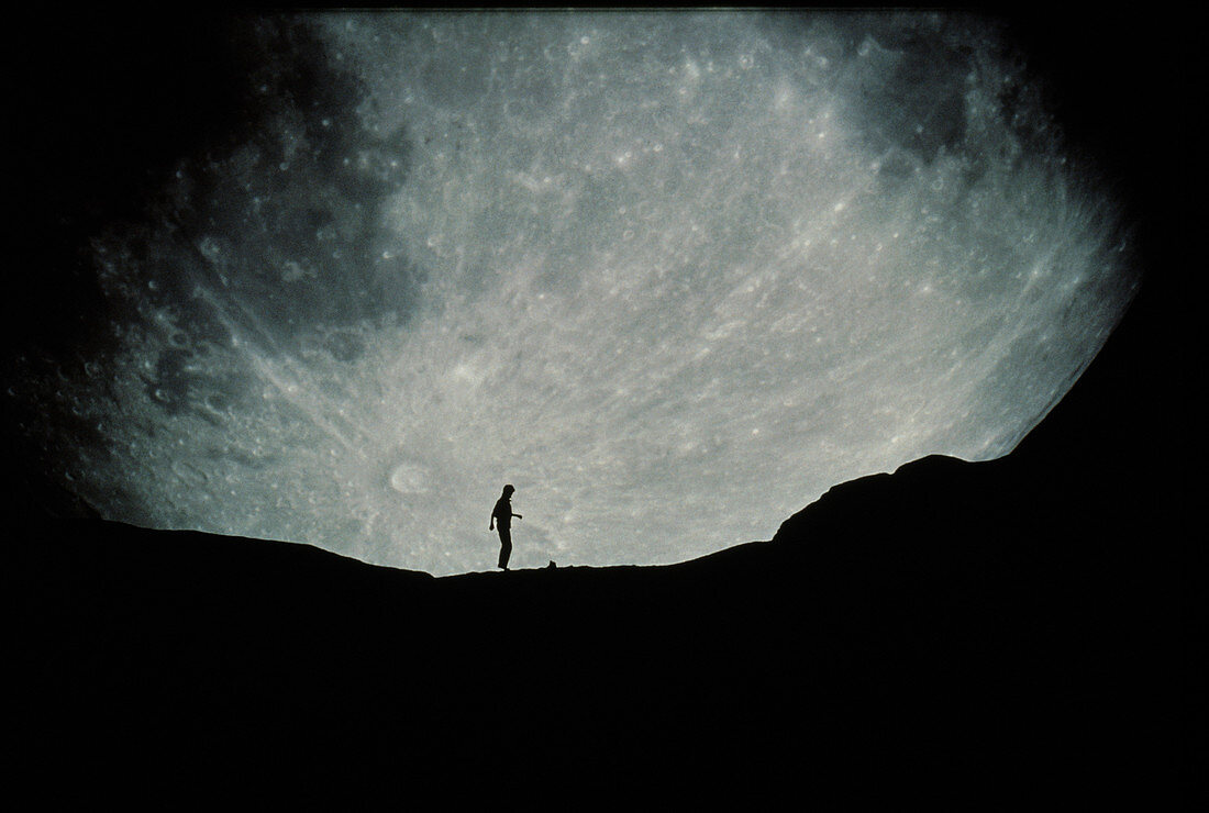 Composite image of Moon behind silhouetted person