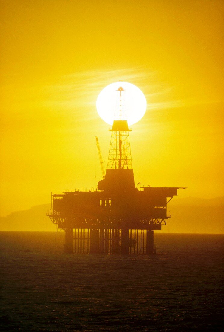 Sunset behind offshore oil rig - CA
