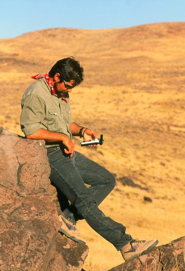Field geologist using hand-held GPS receiver