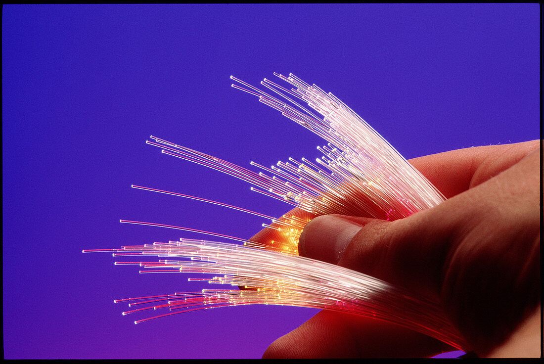 Hand holding optical fibres conducting light