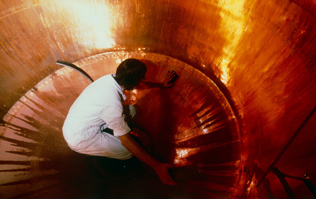Man cleaning inside of brewery vat