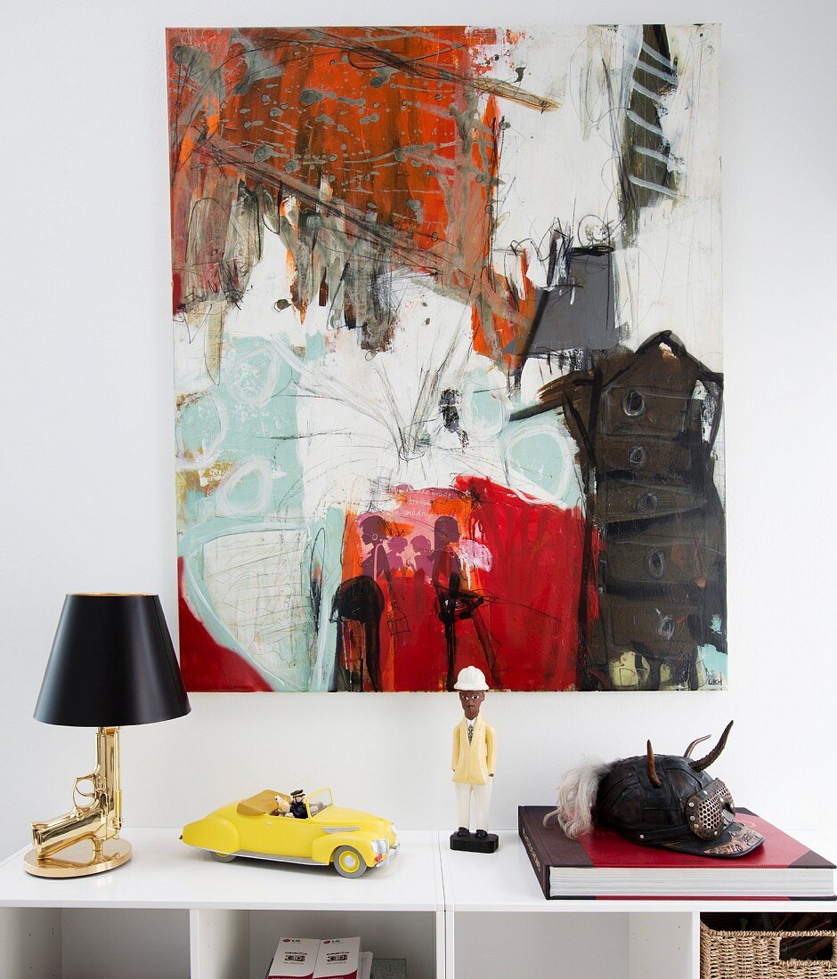 Moderne Kunst an der Wand, Designer-Tischlampe, Minaturauto und Figur auf Ablage