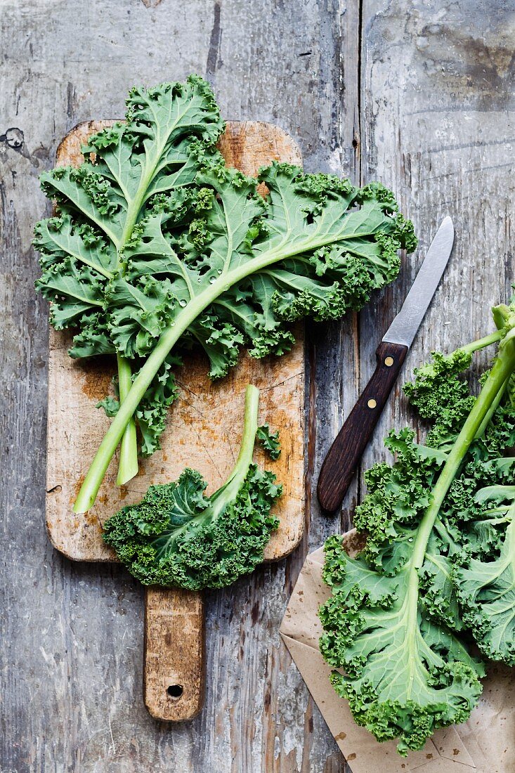 Curly kale on a wooden board with a knife
