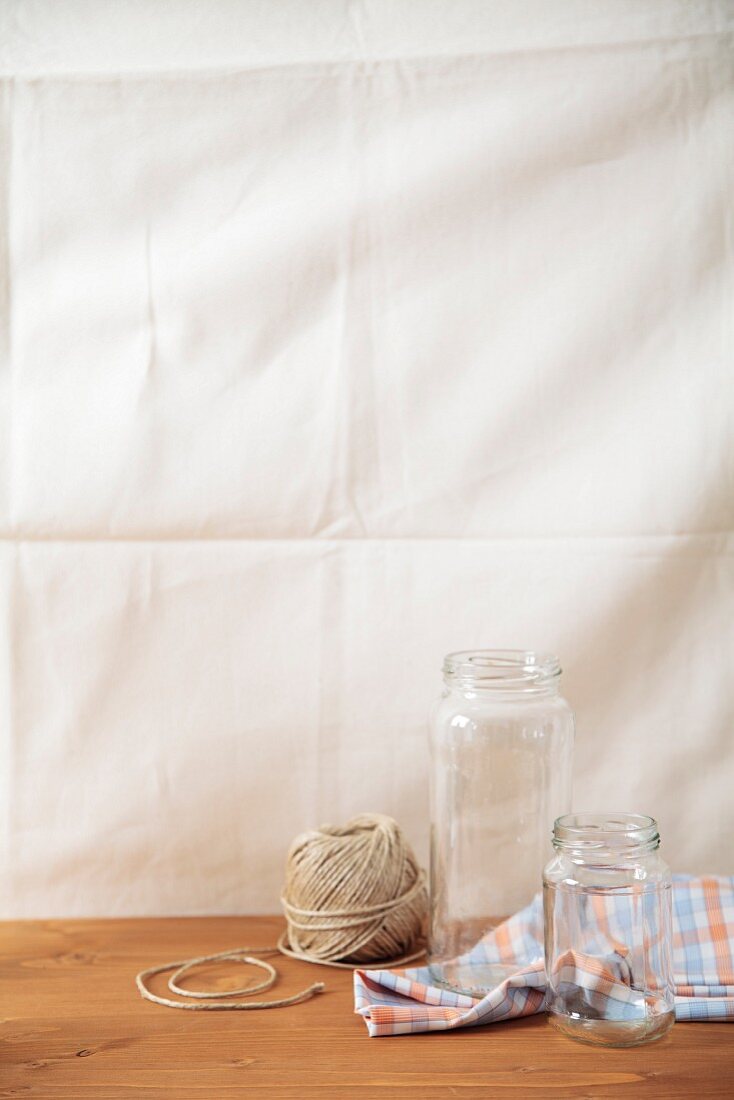An arrangement of preserving jars, a tea towel and a reel of string