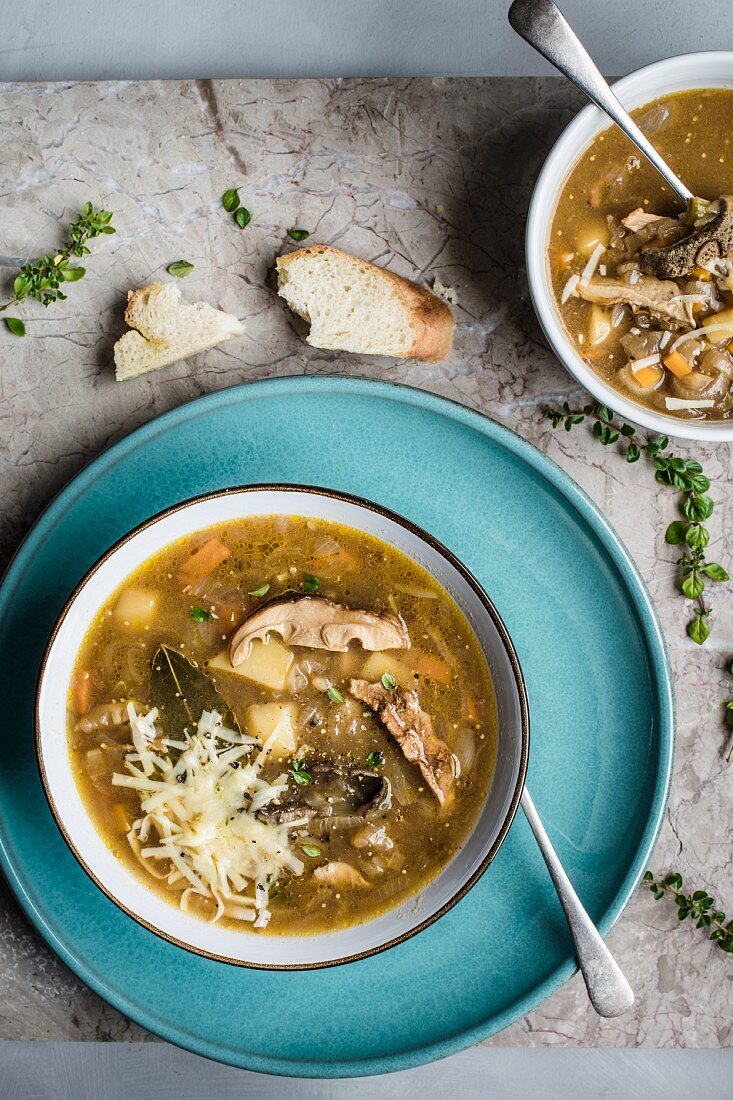 Zwiebel-Waldpilz-Suppe mit geriebenem Käse und Kräutern