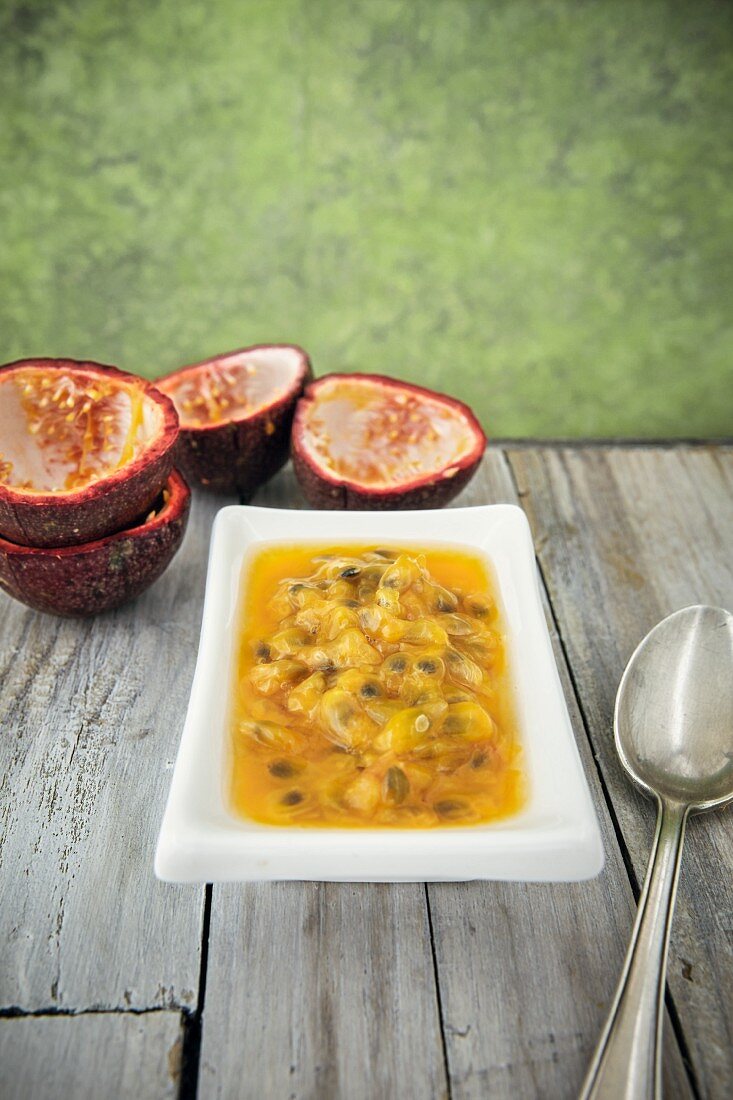 Passionfruit flesh in a dish on a wooden table