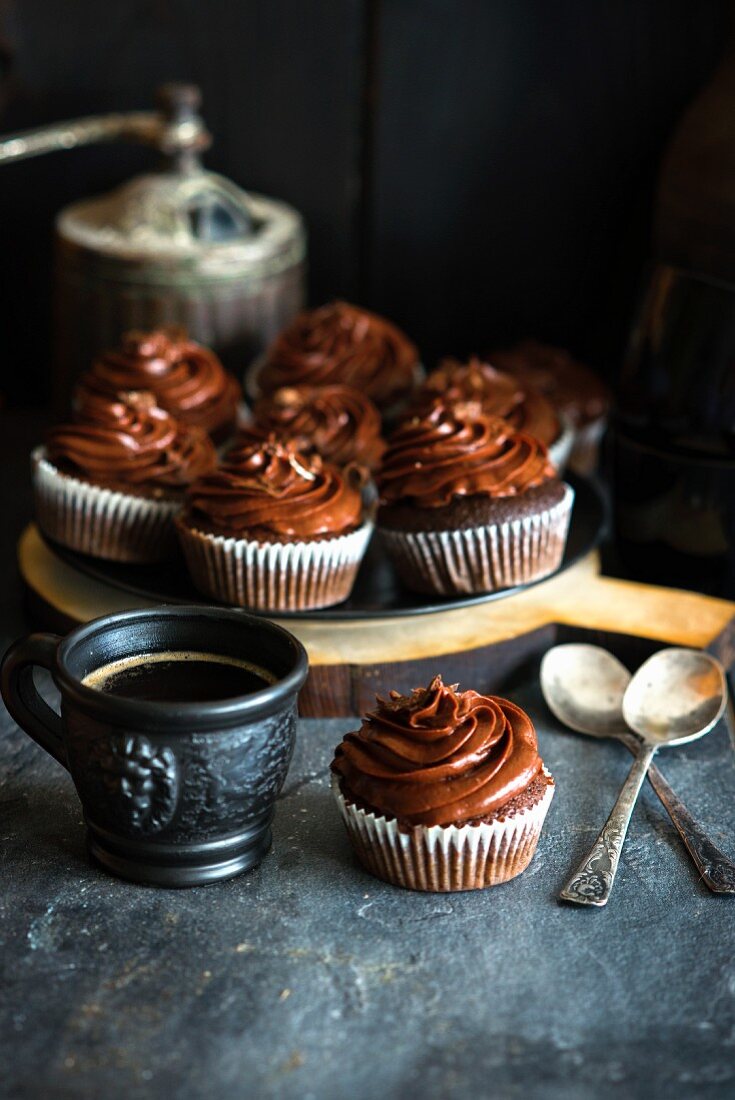 Schokoladencupcakes mit Schokoladen-Frosting und eine Tasse Kaffee