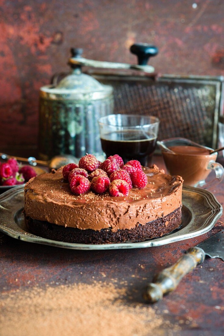 Rich raspberry chocolate mousse cake with moist chocolate sponge, decorated with cocoa powder