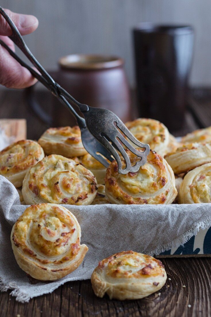 Blätterteigschnecken, gefüllt mit Frischkäse, Käse, Schinken und Lauch