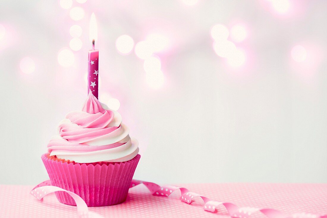 Pink birthday cupcake with copy space to side