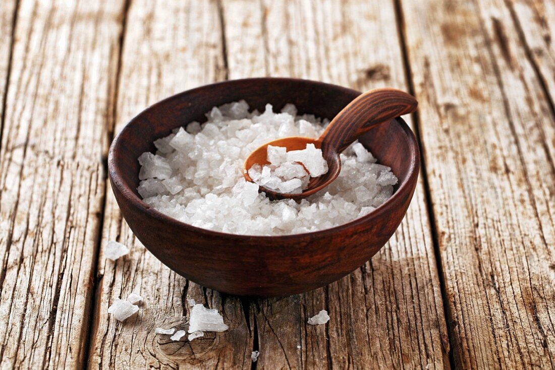 Coarse sea salt in a wooden bowl with a spoon