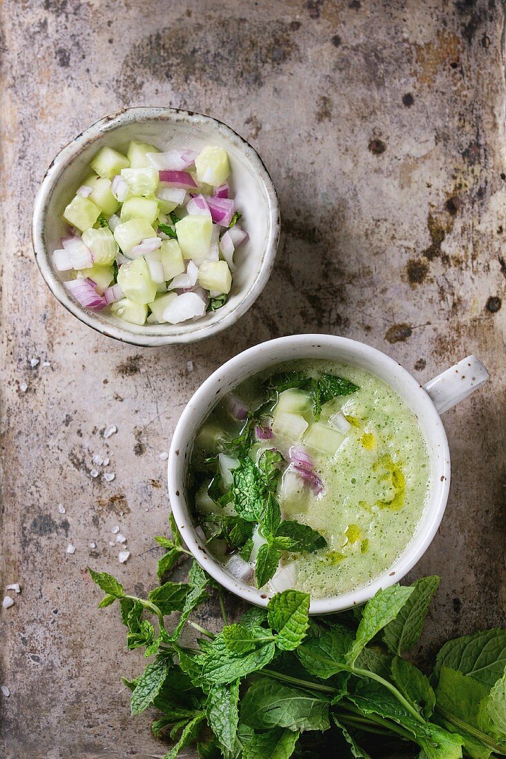 Ceramic cup of cucumber gazpacho cold soup with mint, onion and olive oil