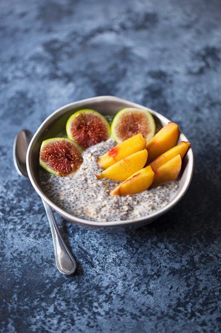 Healthy chia pudding topped with sliced fresh figs and peaches