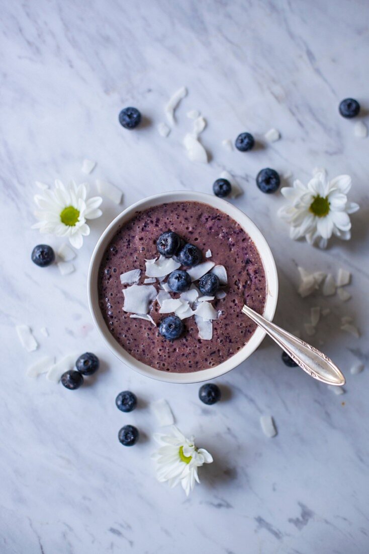 Blueberry smoothie bowl topped with coconut flakes and fresh blueberries