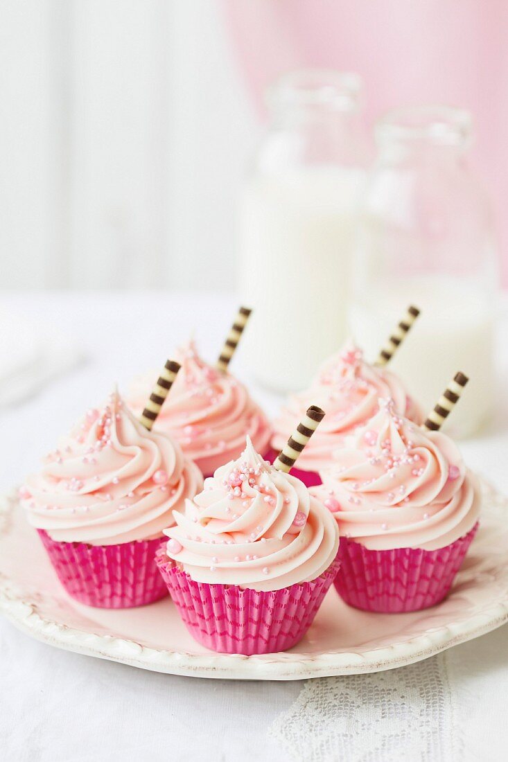 Pink cupcakes decorated with stripey chocolate straws