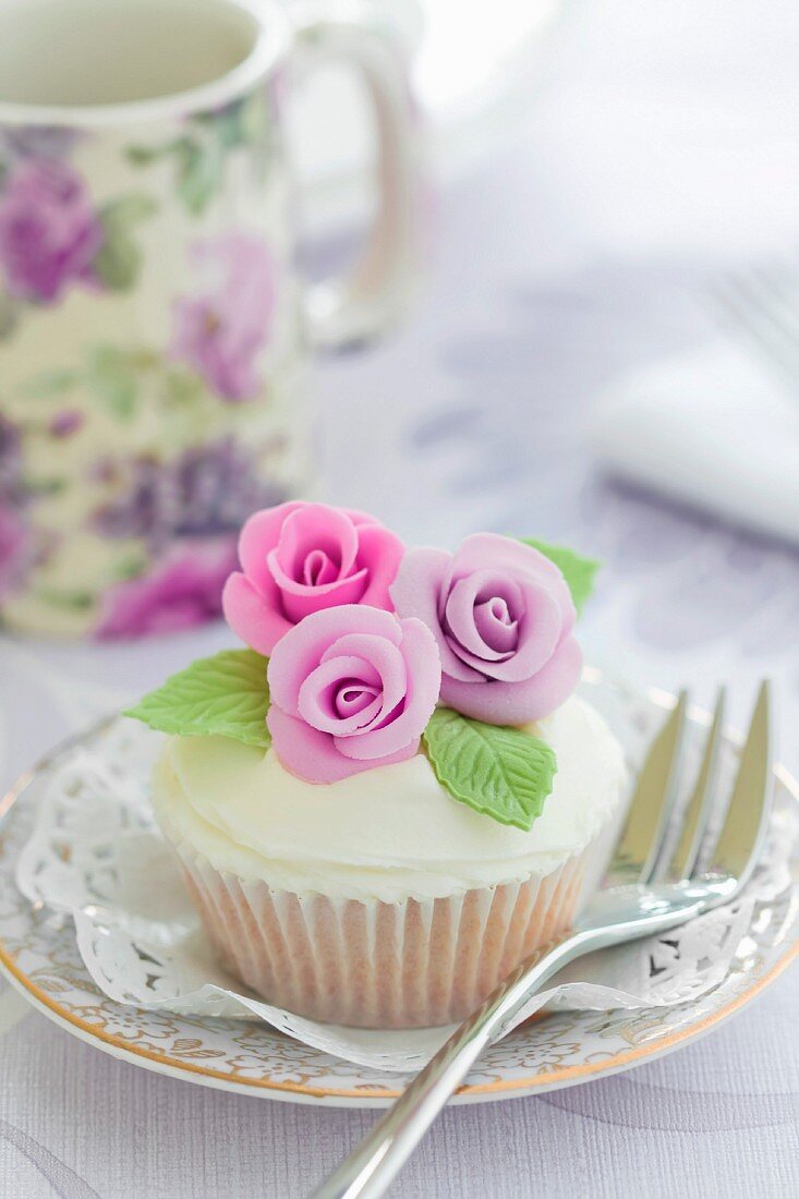 Cupcake, verziert mit lila Zuckerrosen