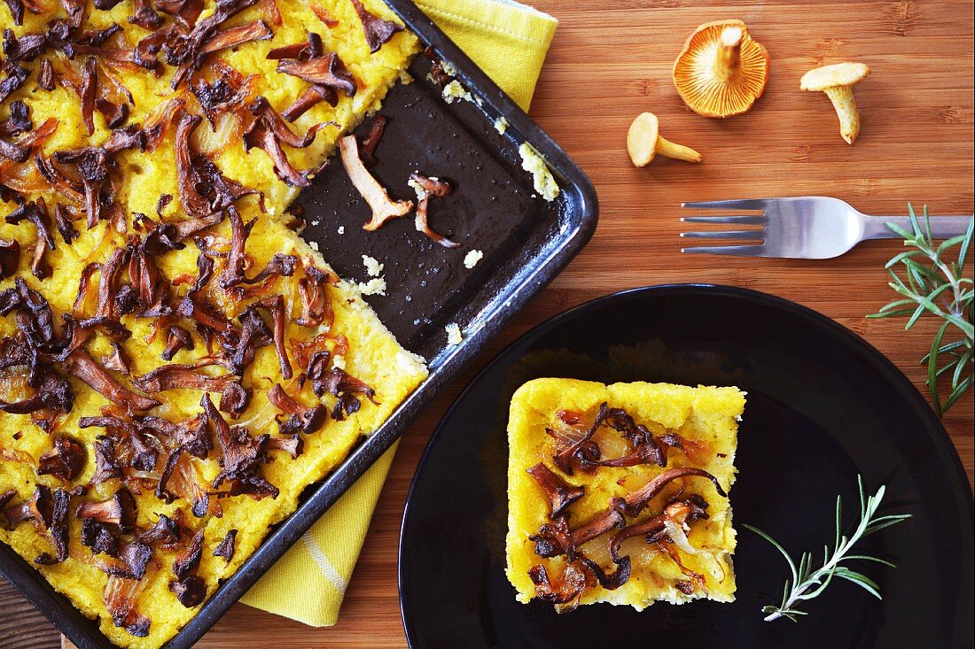 Polentakuchen mit Pfifferlingen und Zwiebeln auf Backblech und Teller