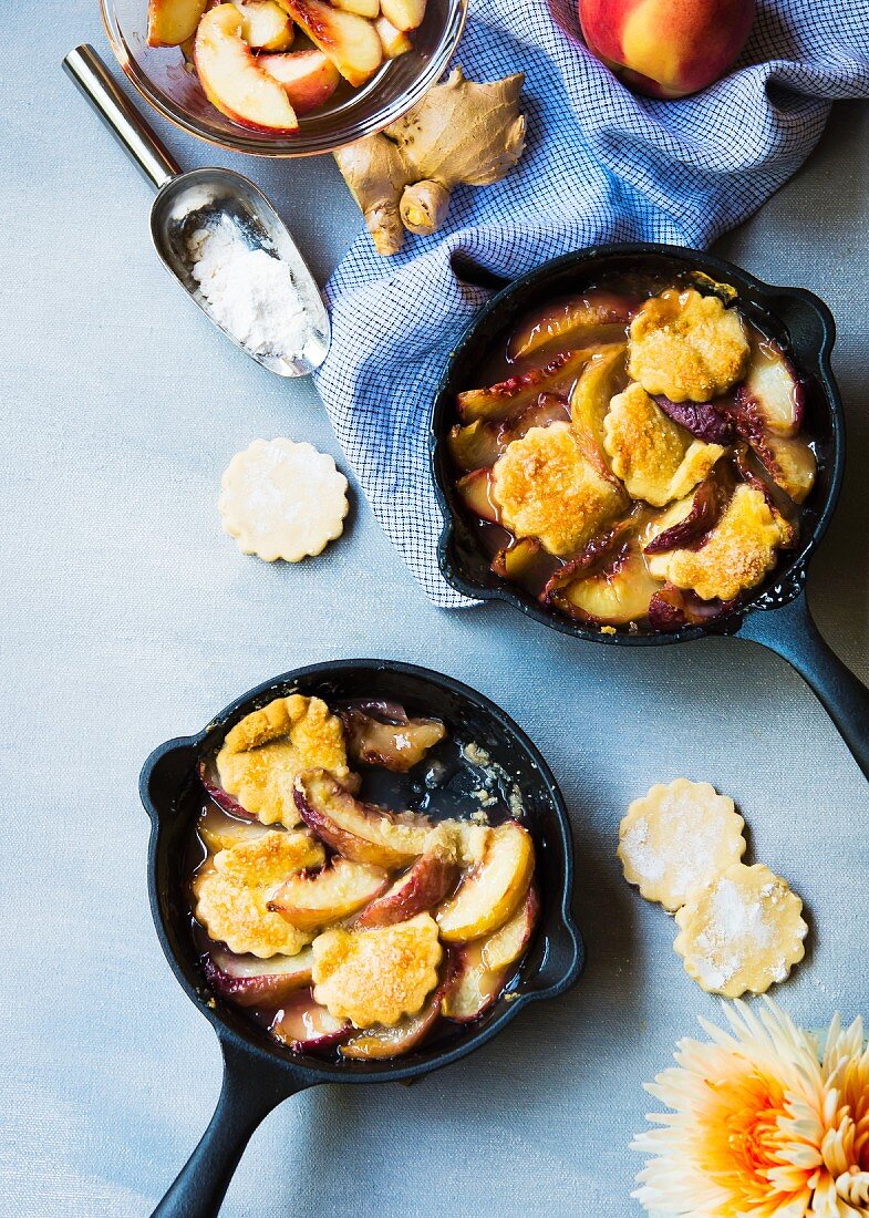 Peach cobbler in small skillets with ginger & cardamon shortbread biscuits