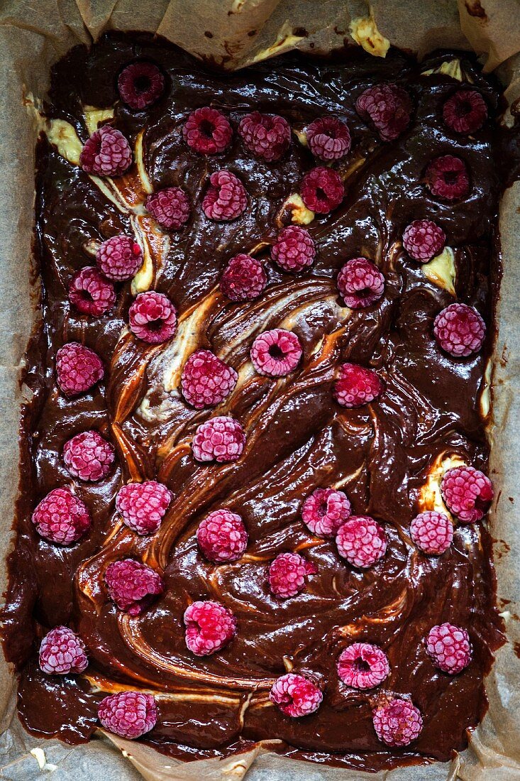 Chocolate and raspberry brownie cheesecake before baking (close-up)
