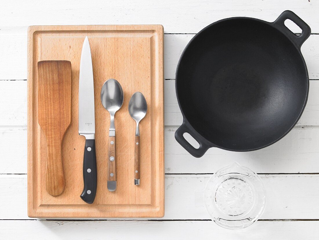 Assorted kitchen utensils: a wok, turner, knife and cutlery