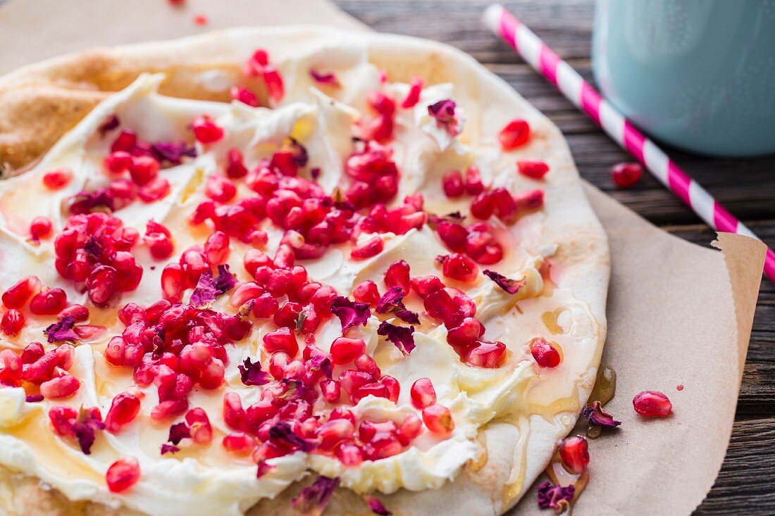 Fladenbrot mit Ziegenfrischkäse, Granatapfelkernen und Rosenblüten