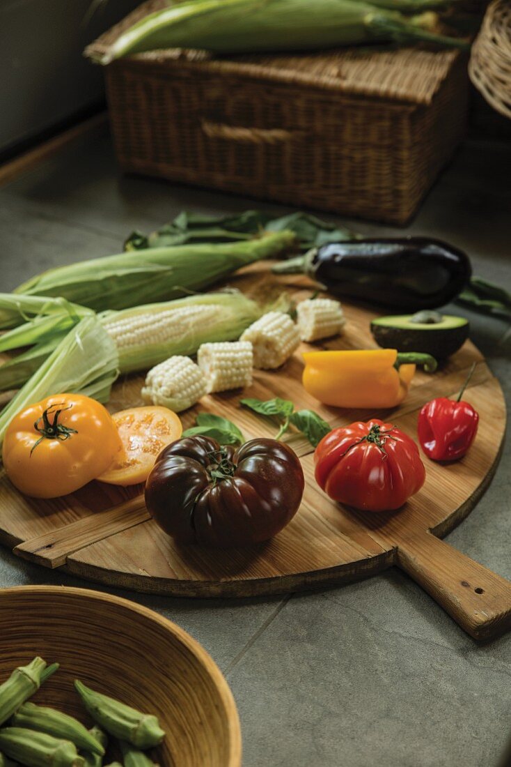 Fresh garden vegetables and corn cob on a wooden platter