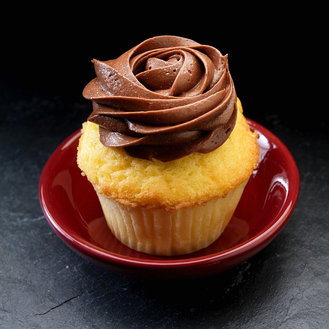 A cupcake with dark chocolate icing