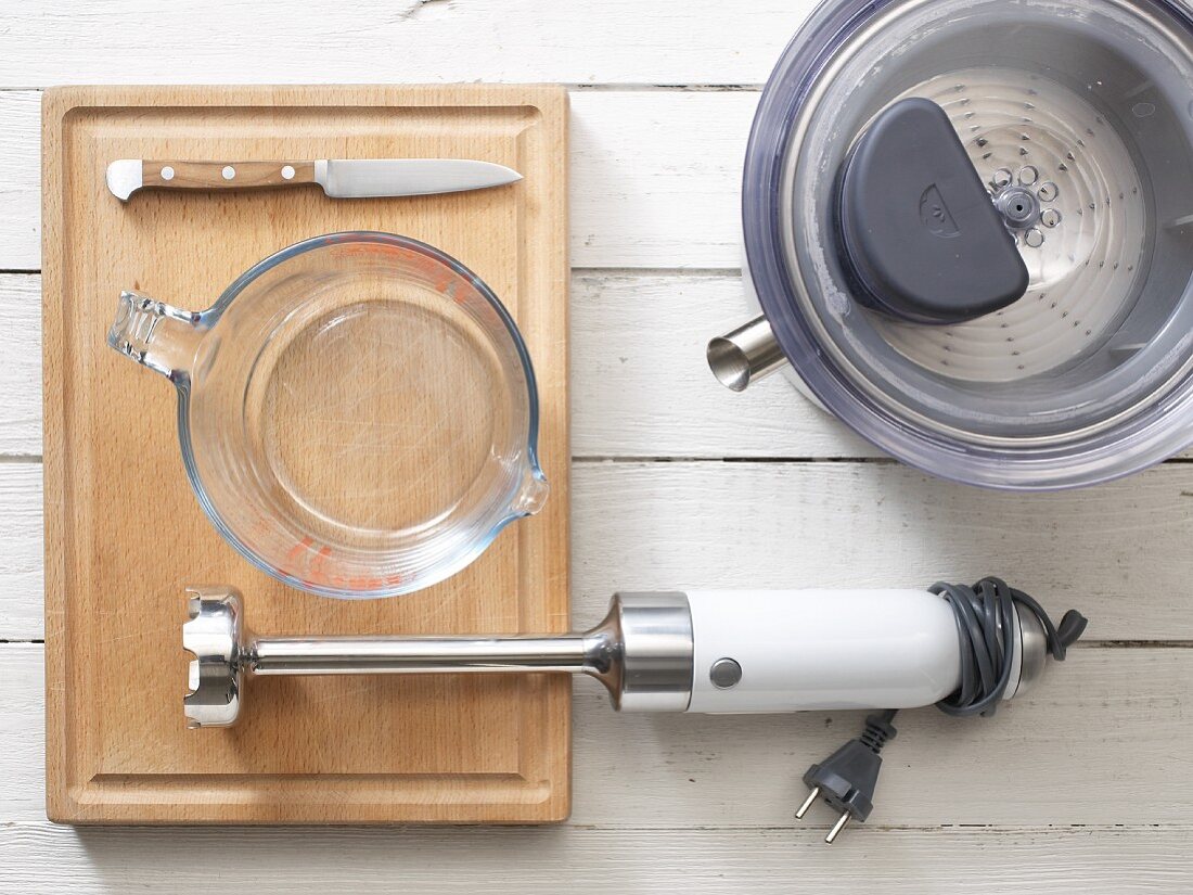 A juicer, hand blender, glass measuring jug and knife