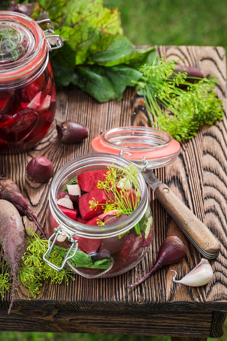 Preserved beetroot in a glass jar on a wooden crate in the garden