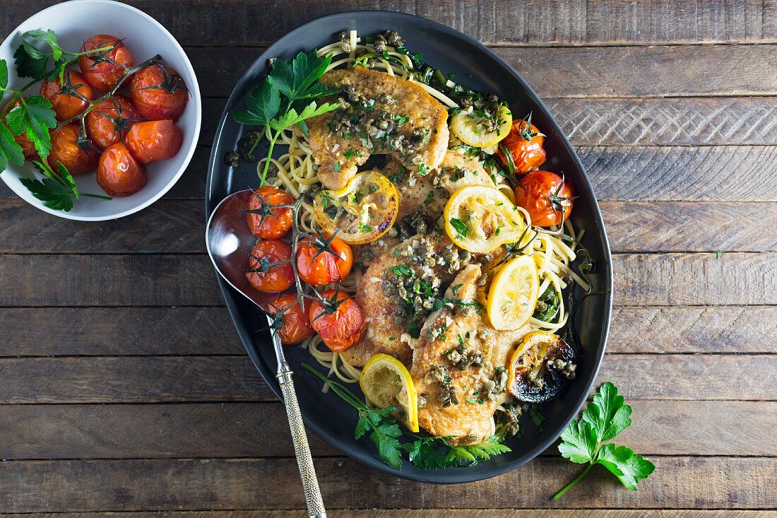 Chicken piccata with tomatoes on a bed of spaghetti