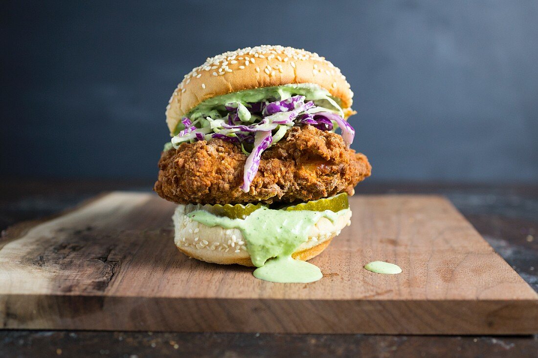 A burger with fried chicken and herb dressing