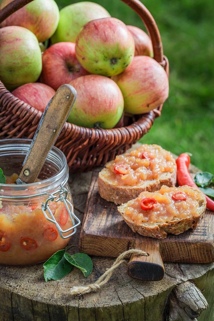 Bread topped with apple and chilli jam on a wooden board in the garden