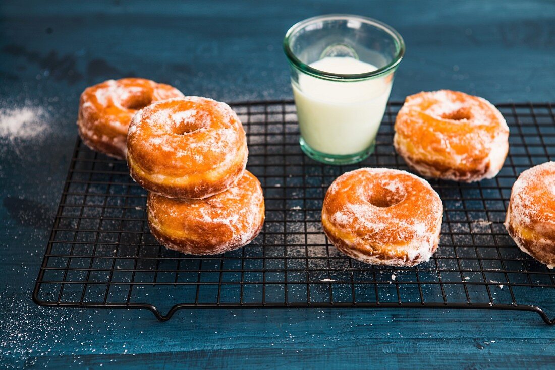 Doughnuts and a glass of milk on a cooling rack