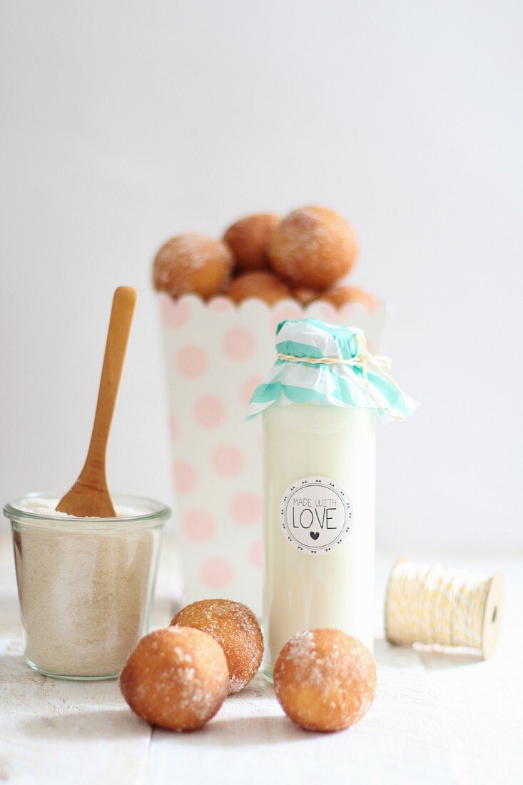 Milk in a decorative glass bottle and quark doughballs with cinnamon sugar