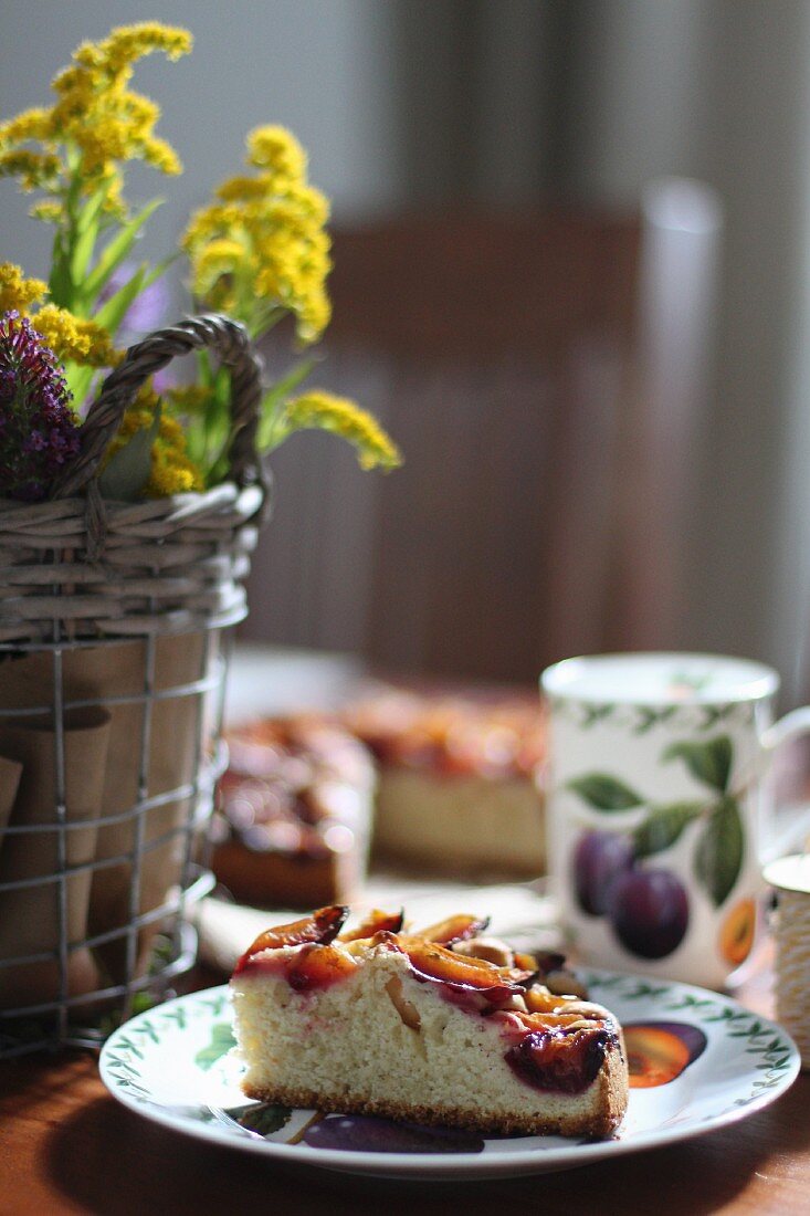 A slice of plum cake on a coffee table with autumn decorations