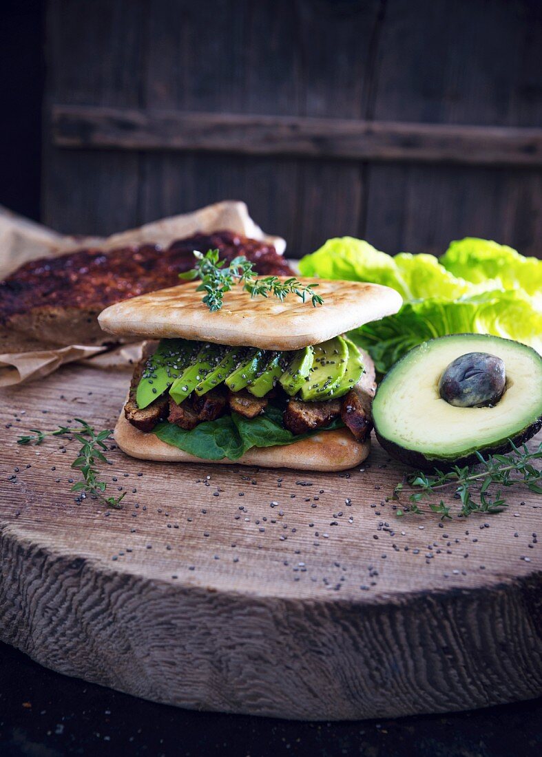 A vegan toasted sandwich with seitan jerky, avocado and chia seeds
