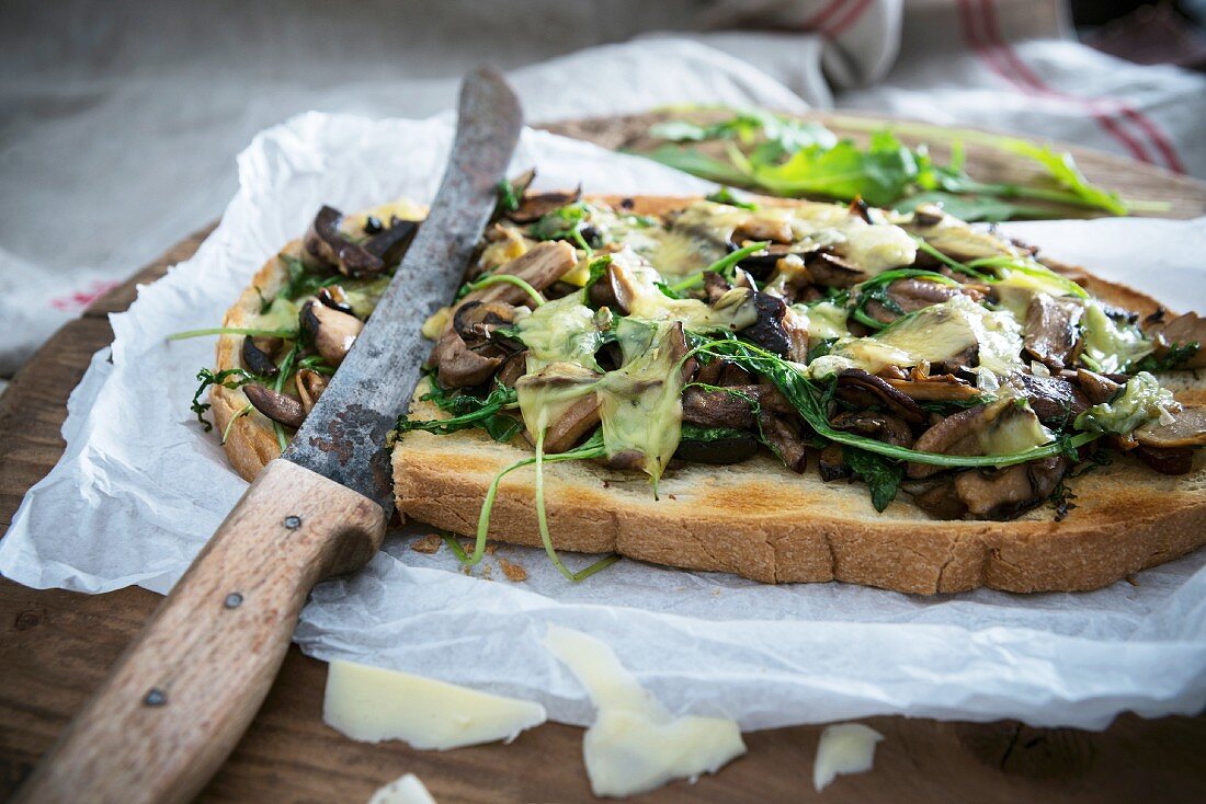 Gratinated toasted bread with wild mushrooms, rocket and cheese (vegan)